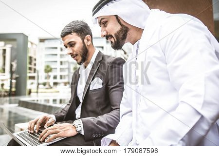 Arabic businessmen in Dubai working at computer