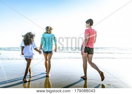 Lesbians mothers with adopted child - Happy homosexual family playing with her daughter