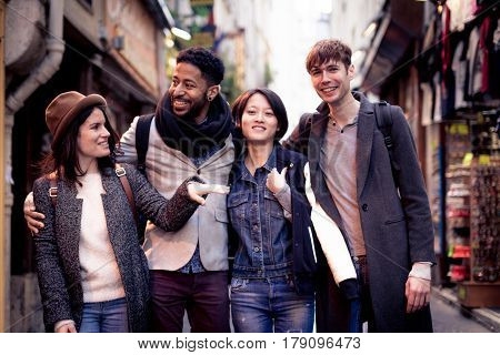Multi-ethnic group of friends having fun in Paris, Latin Quarter, near Notre Dame Cathedral.