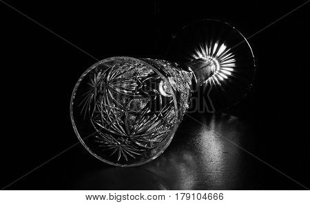 A wine glass for wine, on a black background, reflected from the table