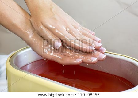 Process paraffin treatment of female hands in beauty salon