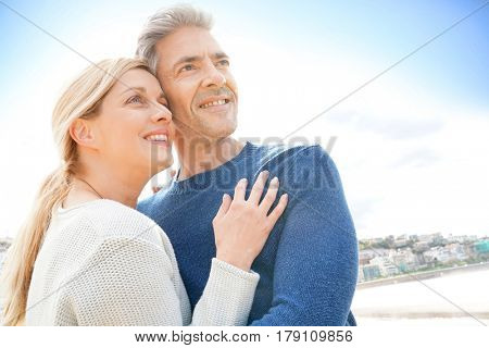 Middle-aged couple embracing each other at the beach