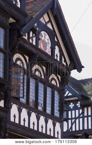 Chester England UK - March 25 2017: Details of ornately carved medieval wooden frame buildings with lead glass windows on Eastgate Street in the historic city of Chester