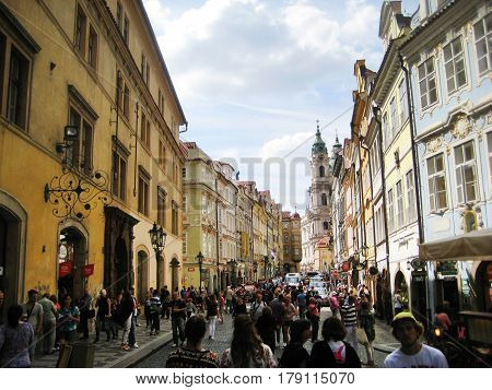 PRAGUE, CZECH REPUBLIC - AUGUST 17, 2016: People walking on Mostecka street near Charles bridge in Prague city center, Czech Republic. Big crowd of people on popular Prague street during summer