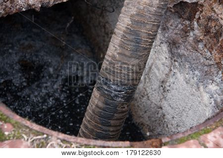 man pumping sewage from the drain hole.