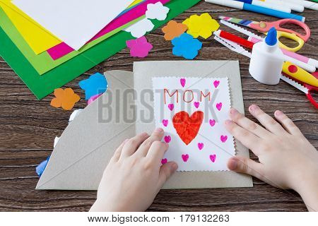 The Child Glues The Details From The Paper To The Postcard. Greeting Card With Flowers On Mother's D