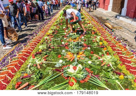 Antigua, Guatemala - March 26 2017: Locals make procession carpet of vegetables during Lent in colonial town with most famous Holy Week celebrations in Latin America.