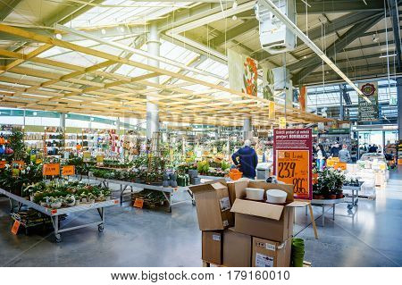 BUCHAREST ROMANIA - APR 1 2016: Seniorman buying flowers for garden inside Hornbach the German DIY-store chain offering home improvement and do-it-yourself goods - customers buying goods selecting the best tools