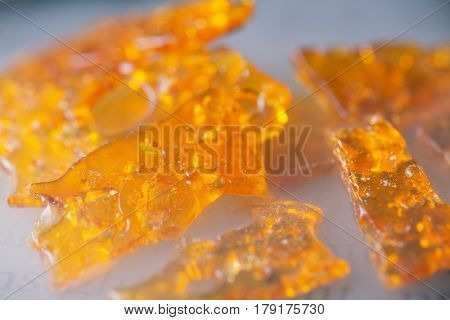 Macro detail of cannabis oil concentrate aka shatter pieces over smoky background used by medical marijuana patients