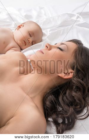 Young pretty mother and her lovely baby boy sleeping studio shot