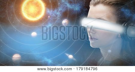 Close up of brunette experiencing virtual reality simulator against graphic image of planets and sun 3d