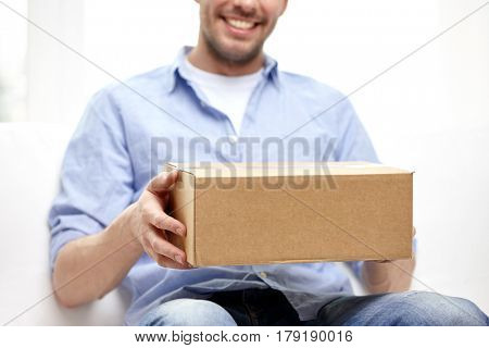 delivery, mail and people concept - happy smiling man with cardboard box or parcel at home