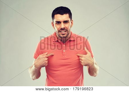 emotion, gesture, argue and people concept - arguing angry man pointing finger to himself over gray