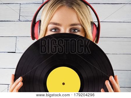Digital composite of Woman with headphones and record against white panel