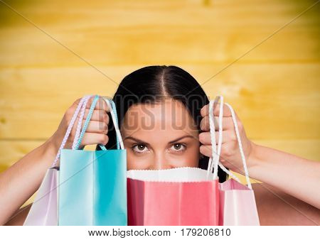 Digital composite of Woman with shopping bags against yellow wood panel