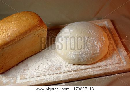 The process of baking. Ingredients. Flour into a bowl with a spoon and eggs in a plate rolling pin whisk strainer spices and milk on a wooden background. Spilling flour chaos confusion