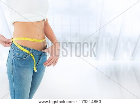 Digital composite of Woman mid section with measuring tape against blurry window