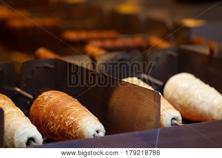 Traditional national czech street desert - Trdelnik. Baking of czech trdelnik on the street of Prague.