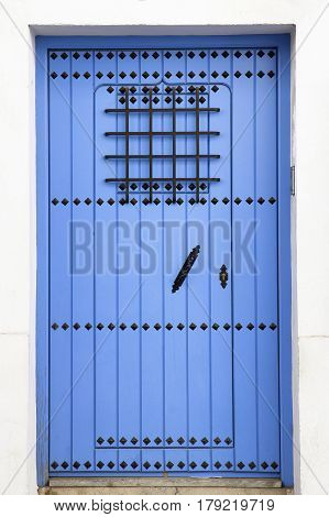 typical andalusian blue door on white facade