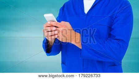 Digital composite of Mechanic holding up phone against blurry blue wood panel