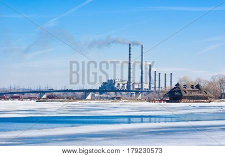 Electric power station beside a river - winter industrial landscape in Ukraine.