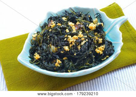 Chinese Traditional Food, Stir Fried Jute Leaves or Mulukhiyah Leaves with Garlics and Fermented Soy Bean.