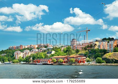 View to Stockholm, Sweden with a ferry from sea in summer. Nacka strand houses and harbour on sunny day