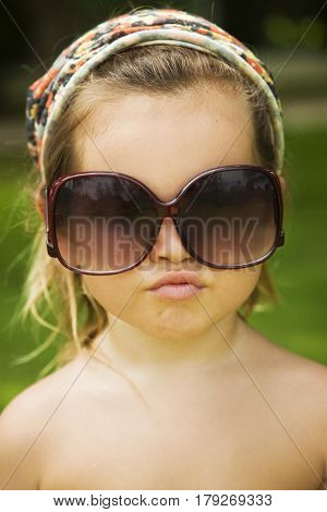 The little girl wears a large adult sunglasses Asian