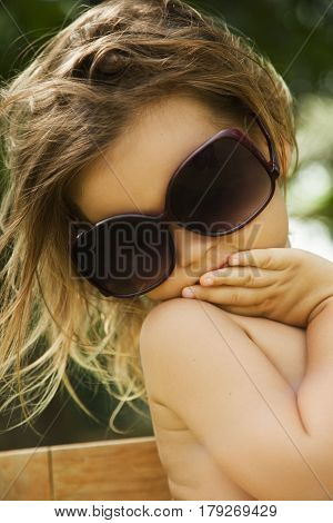 The little girl wears a large adult sunglasses Asian-mestizo