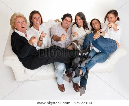  Familie gruppe sidder på en sofa, griner og peger kameraet