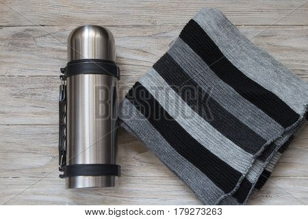 Metal thermos flask on a woden background. Top view