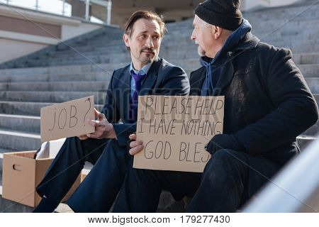 Lost my job. Two luckless men sitting on the steps looking at each other while having problems in life