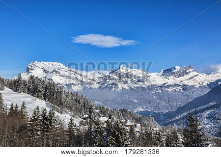 Chain of peaks in Alps above the clouds and villages