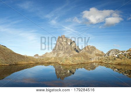Midi Dossau Peak reflected in a lake. Ossau Valley, Pyrenees National Park, Pyrenees, France.
