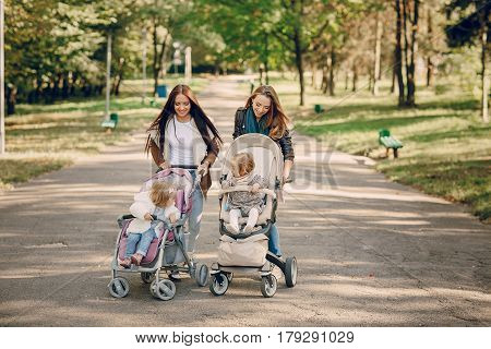 young mother walking with her baby and carries it in a beautiful pram