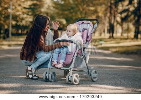 young mother walking with her baby and carries it in a beautiful pram