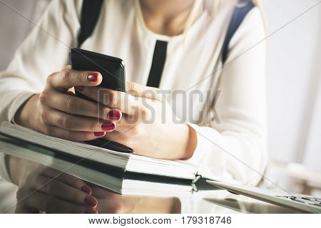 Close up of female hands using smartphone at wokrplace. Social media concept