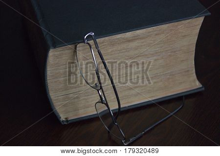 Still life weary readers. The book and glasses on the table