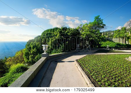 Alley and green flowerbeds with the view on sea