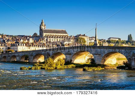 Old bridge over the Loire at sunset in Blois, France. Cathedral of Blois in the background.