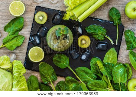 Detox diet. Green smoothie with fruits and vegetables on wooden dark background.