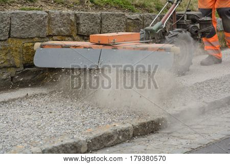 Sweeper cleans bourgeon dough from loose chippings - close-up