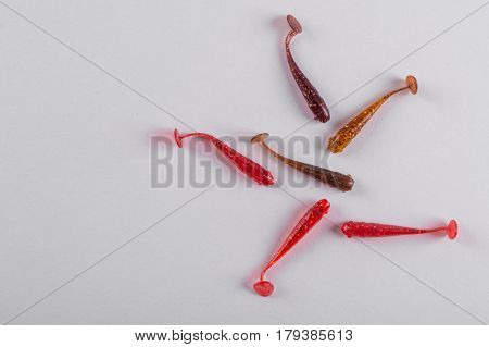 Little colorful silicone fishing baits on white background