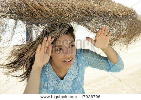 Portrait de femme vêtue bleue, journée ensoleillée de la plage parasol