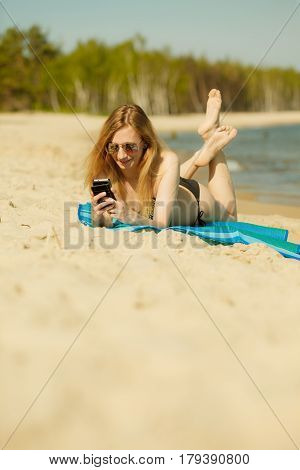Woman In Bikini Sunbathing And Relaxing On Beach