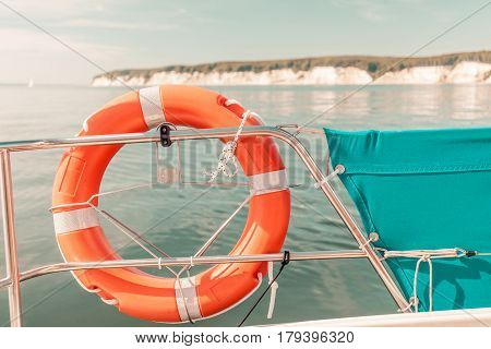 Detailed close up of rescue ring on sailing boat handrail during cruise on water Sassnitz cliff in background.