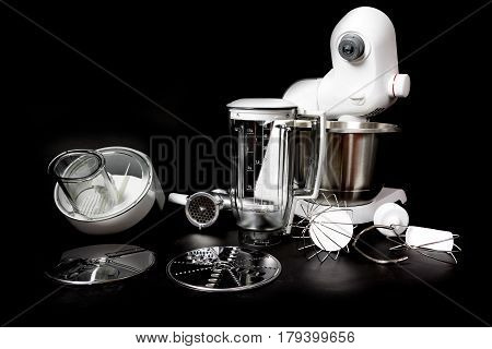 Kitchen robot with complete equipment closeup. All is on the black background. All potential trademarks are removed.