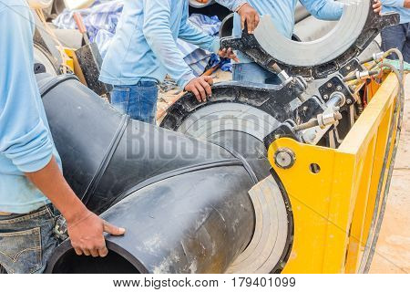 Construction site water supply project at working for welding the connecting of HDPE pipe by blue color uniform constructor