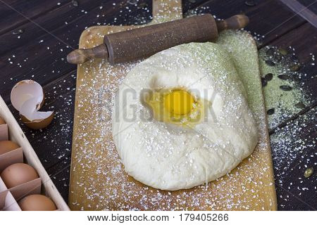 Raw dough for delicious baking with ingredients. On a wooden table