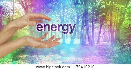 Nature's Energy is a Beautiful Thing  - female hands with the word ENERGY floating between in front of an ethereal rainbow colored bokeh effect magical woodland scene  and copy space